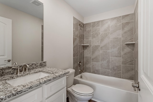 full bathroom with vanity, tiled shower / bath combo, and toilet