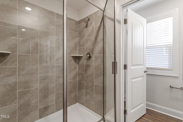 bathroom featuring a shower with shower door and hardwood / wood-style flooring