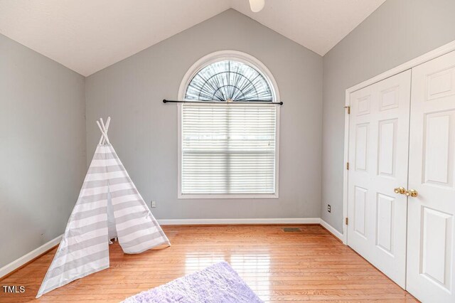 game room with light hardwood / wood-style floors and vaulted ceiling