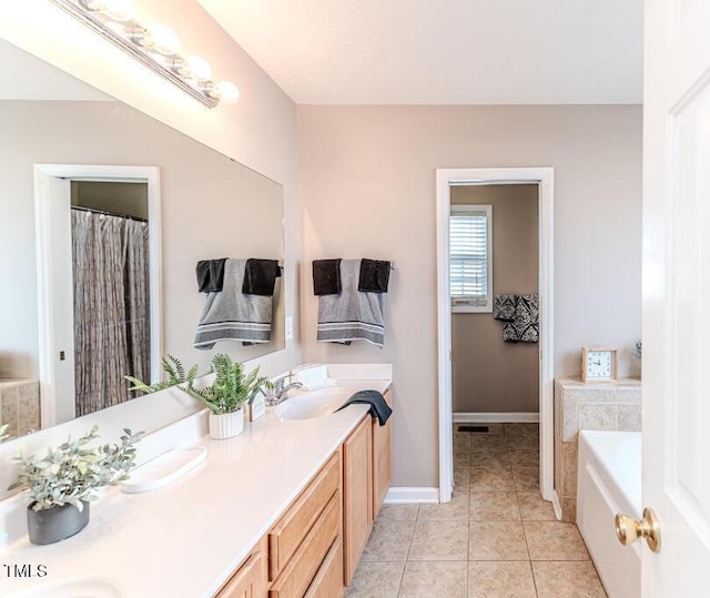 bathroom featuring tile patterned flooring, vanity, and a bath