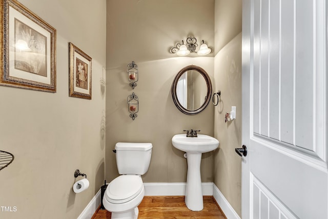 319 River Knoll Dr, Clayton, NC 27527 - half bathroom featuring a sink, toilet, wood finished floors, and baseboards