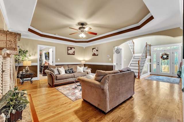 319 River Knoll Dr, Clayton, NC 27527 - living room featuring ceiling fan, a tray ceiling, arched walkways, ornamental molding, and stairway