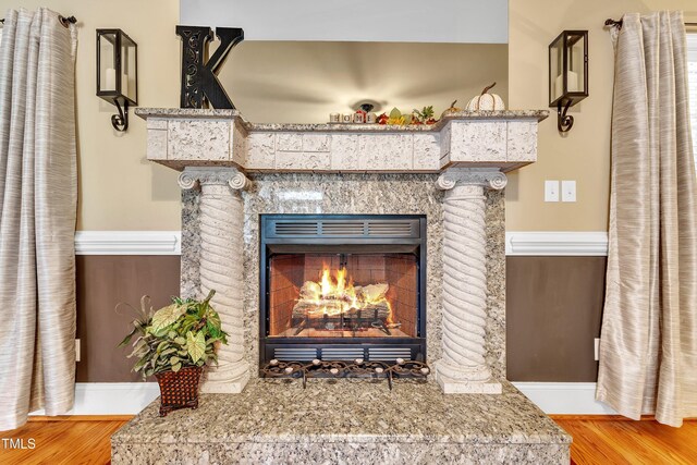 319 River Knoll Dr, Clayton, NC 27527 - details featuring baseboards, a warm lit fireplace, and wood finished floors