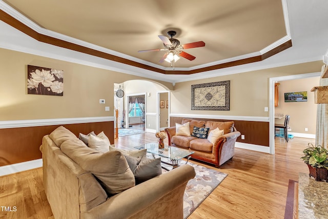 319 River Knoll Dr, Clayton, NC 27527 - living area featuring arched walkways, ceiling fan, crown molding, a tray ceiling, and wainscoting