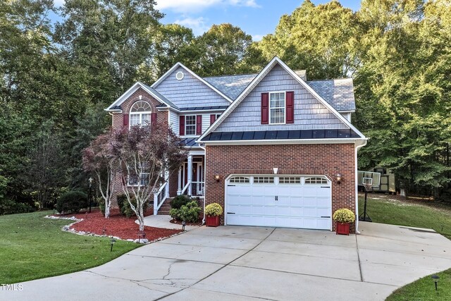 319 River Knoll Dr, Clayton, NC 27527 - view of front facade with a garage, concrete driveway, brick siding, a front lawn, and a standing seam roof