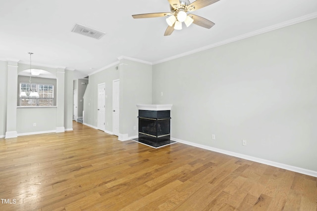 unfurnished living room featuring light wood-type flooring, crown molding, a multi sided fireplace, and ceiling fan with notable chandelier