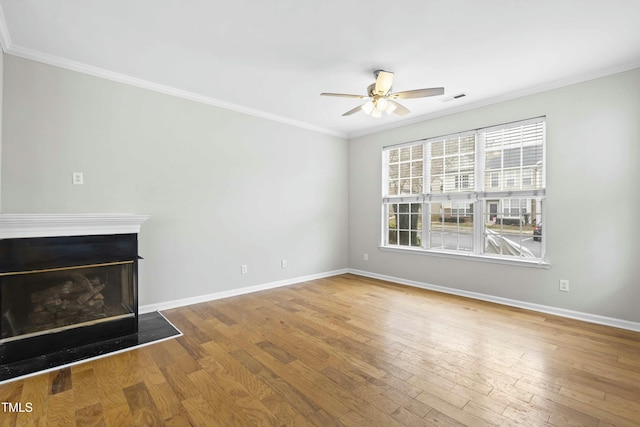 unfurnished living room featuring ceiling fan, wood-type flooring, and ornamental molding