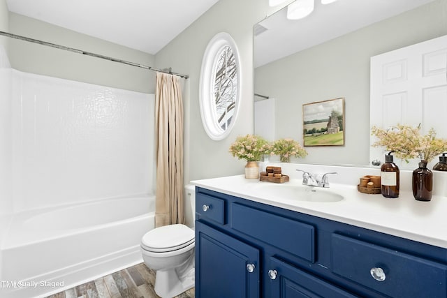 full bathroom featuring toilet, shower / bath combination with curtain, hardwood / wood-style floors, and vanity