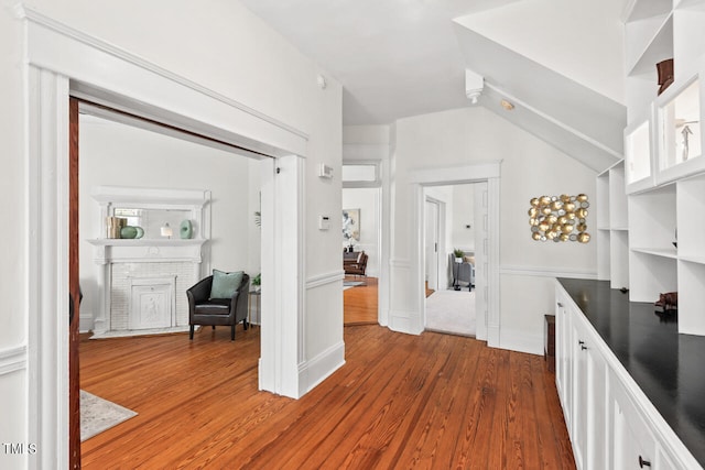 kitchen with white cabinets, vaulted ceiling, and dark hardwood / wood-style flooring