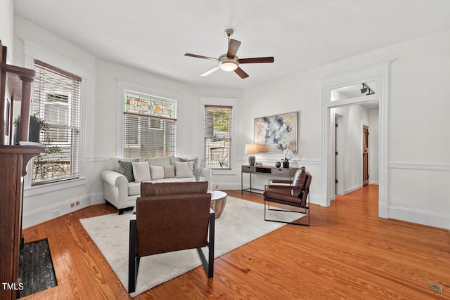 living room featuring light hardwood / wood-style flooring and ceiling fan