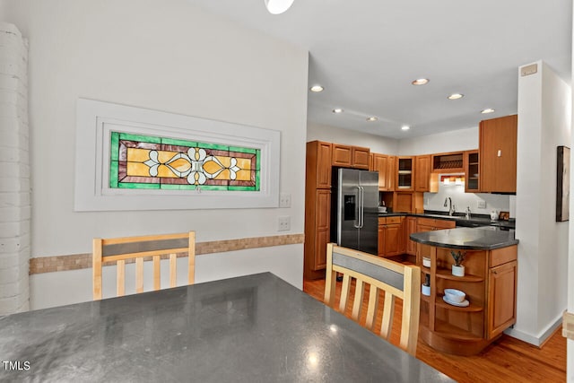 kitchen featuring light hardwood / wood-style floors, decorative columns, sink, and stainless steel refrigerator with ice dispenser