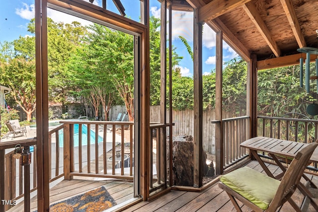 unfurnished sunroom with vaulted ceiling with beams