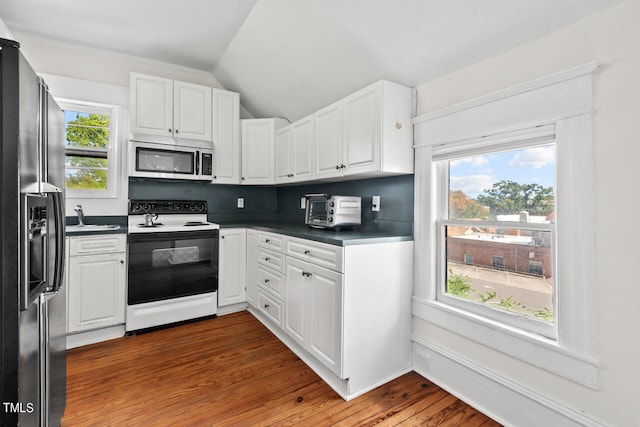 kitchen with hardwood / wood-style floors, a healthy amount of sunlight, white electric range oven, and fridge with ice dispenser