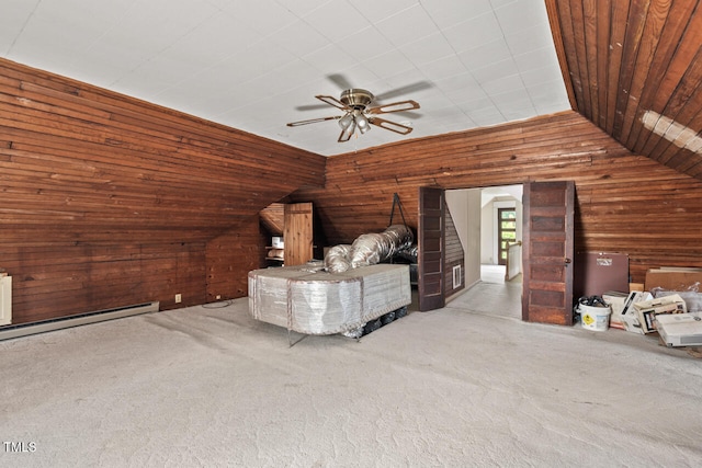 interior space with lofted ceiling, wood walls, light colored carpet, and ceiling fan