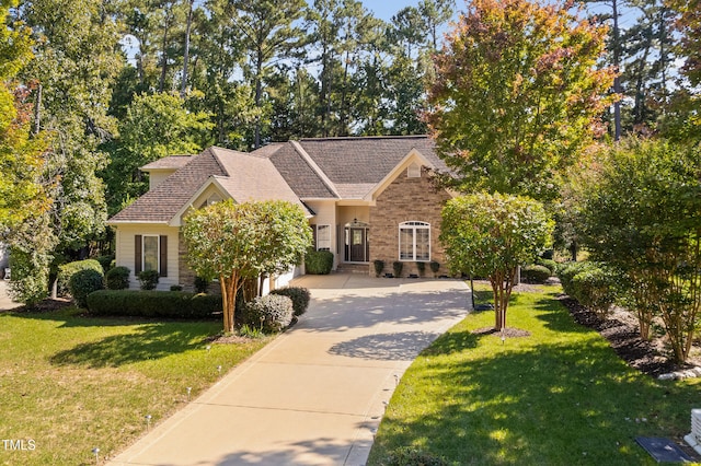 view of front of property featuring concrete driveway, an attached garage, brick siding, and a front lawn