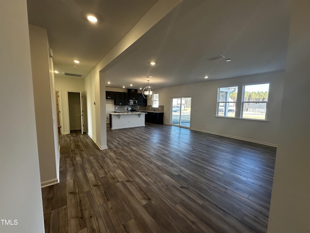 unfurnished living room with dark hardwood / wood-style flooring and a notable chandelier