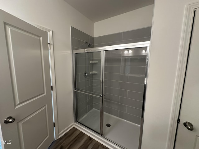 bathroom with hardwood / wood-style flooring and an enclosed shower