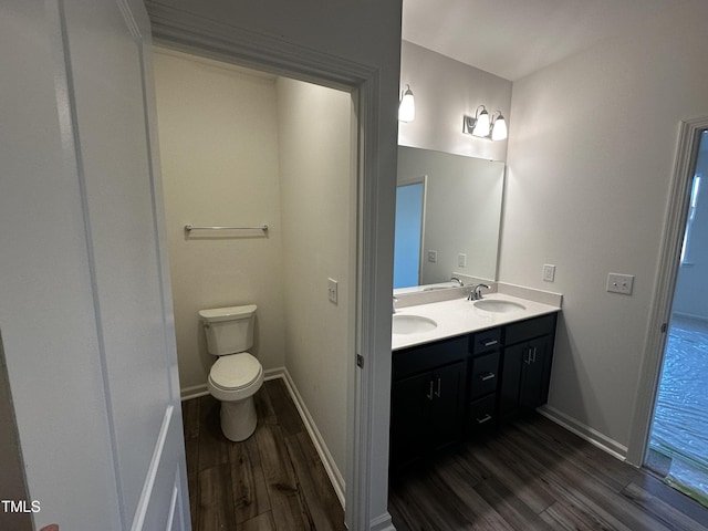 bathroom featuring wood-type flooring, vanity, and toilet