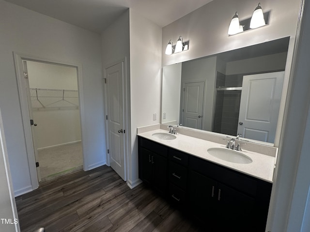 bathroom with walk in shower, vanity, and hardwood / wood-style floors