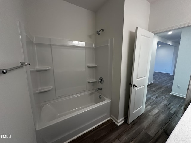 bathroom with hardwood / wood-style flooring and shower / tub combination