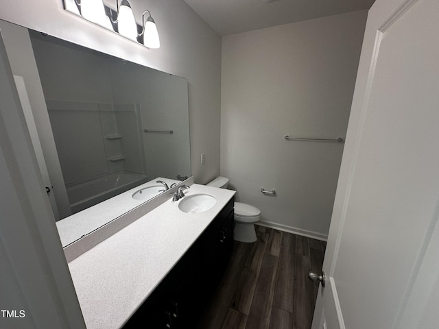 full bathroom featuring vanity, hardwood / wood-style floors, shower / bathtub combination, and toilet