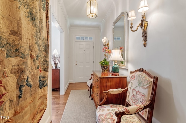 foyer entrance with light hardwood / wood-style flooring and crown molding