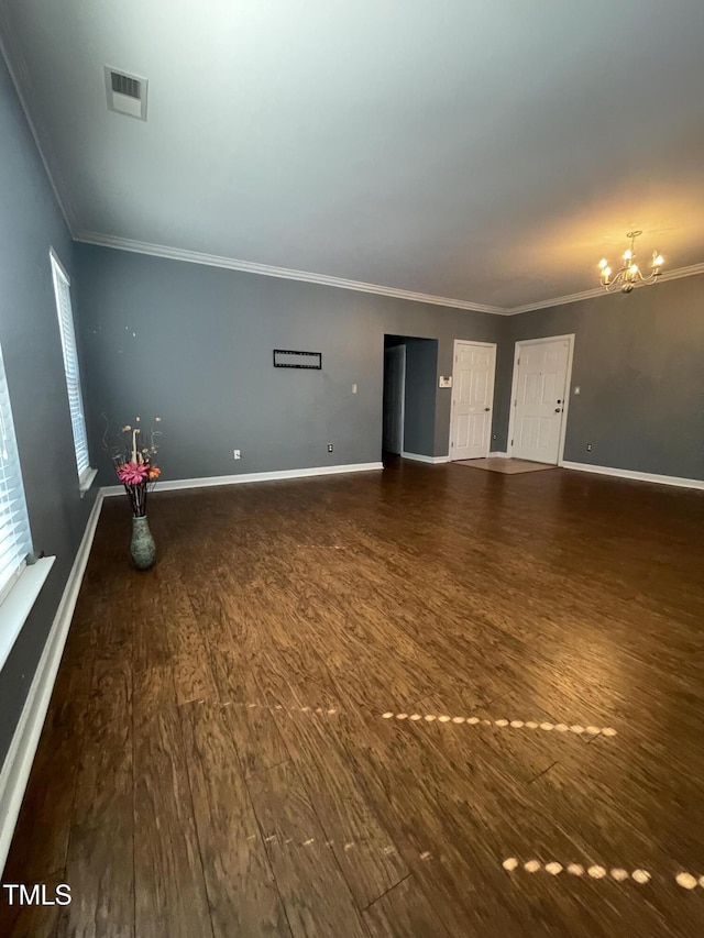 unfurnished living room featuring ornamental molding, dark wood-type flooring, and a chandelier