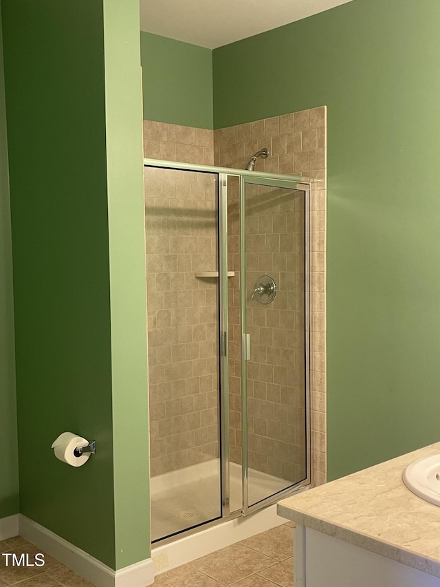 bathroom featuring tile patterned flooring, vanity, and walk in shower