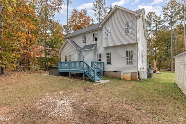 rear view of property with a lawn, a wooden deck, and cooling unit