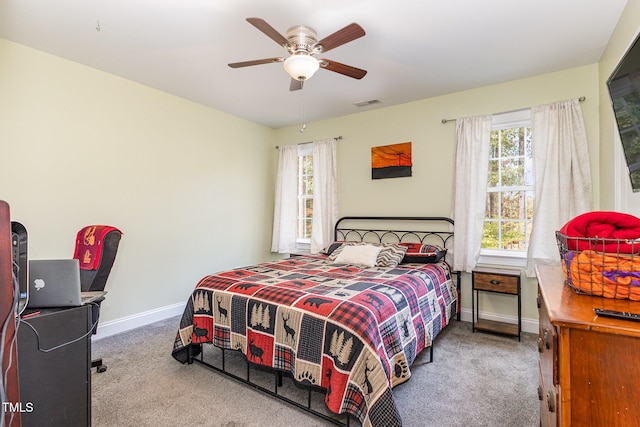 carpeted bedroom with multiple windows and ceiling fan