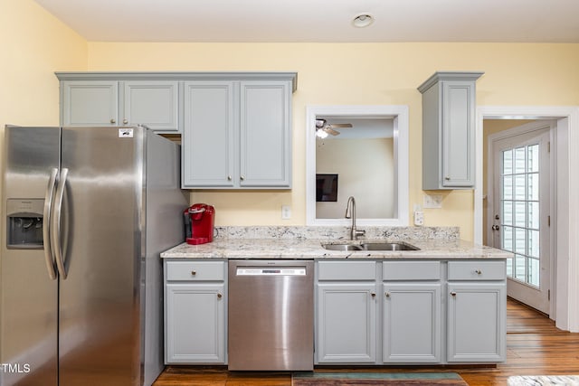 kitchen with stainless steel appliances, plenty of natural light, sink, and hardwood / wood-style floors