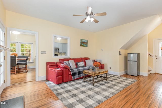 living room with light wood-type flooring and ceiling fan