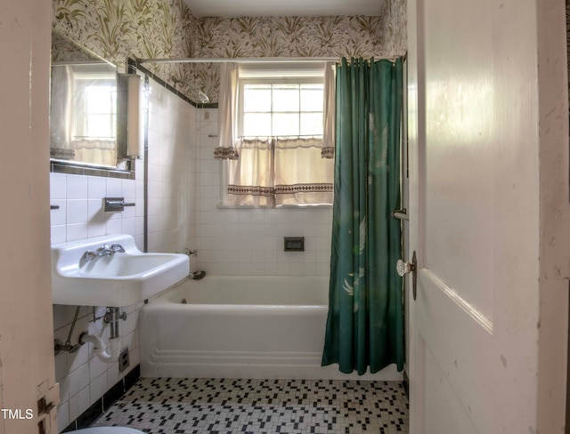 bathroom featuring sink, tile walls, and shower / bathtub combination with curtain