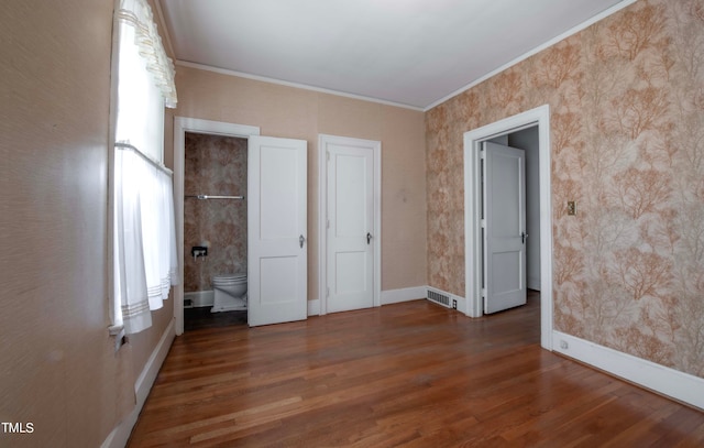 unfurnished bedroom with crown molding, ensuite bath, and dark hardwood / wood-style floors