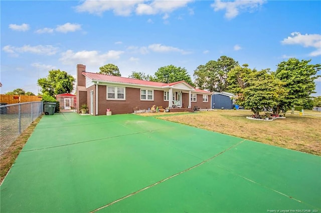 view of front of property with a storage shed and a front yard