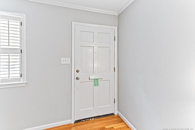 doorway with crown molding and light hardwood / wood-style floors