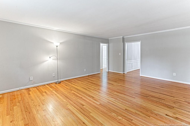 unfurnished room featuring ornamental molding and light wood-type flooring