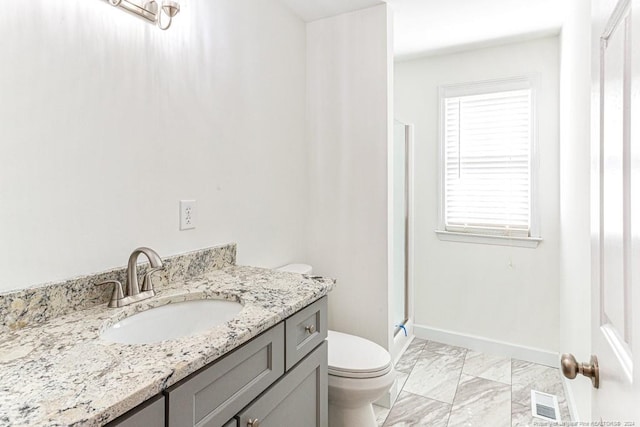 bathroom with vanity, walk in shower, and toilet