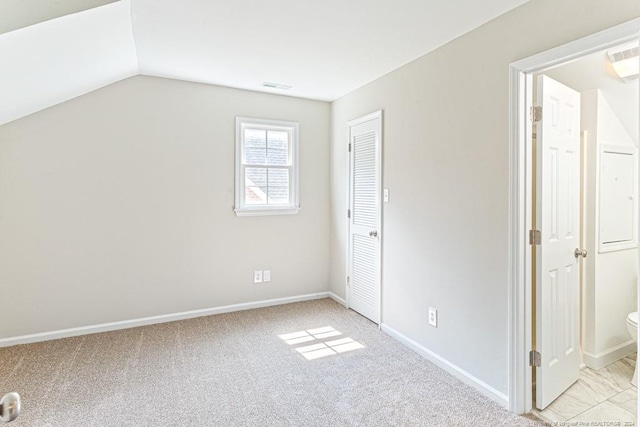 bonus room with lofted ceiling and light colored carpet