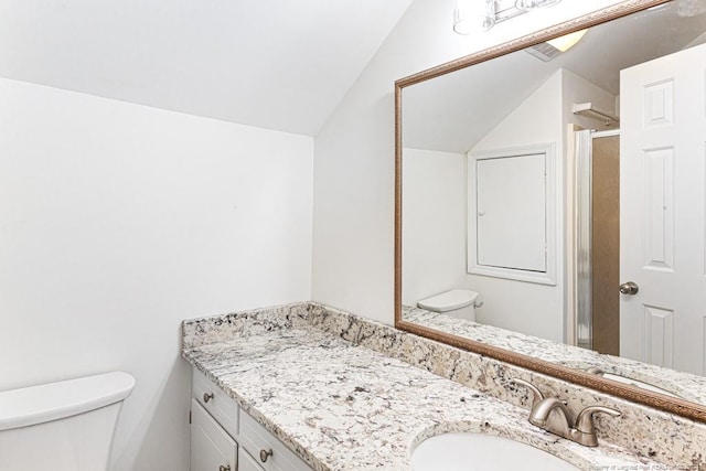 bathroom with vanity, lofted ceiling, toilet, and a shower with door