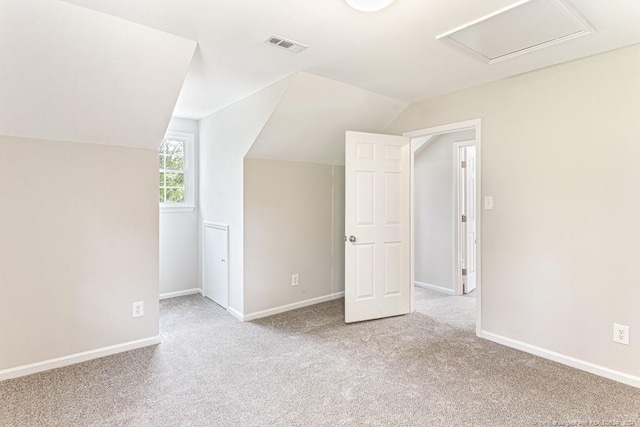 additional living space featuring lofted ceiling and light colored carpet