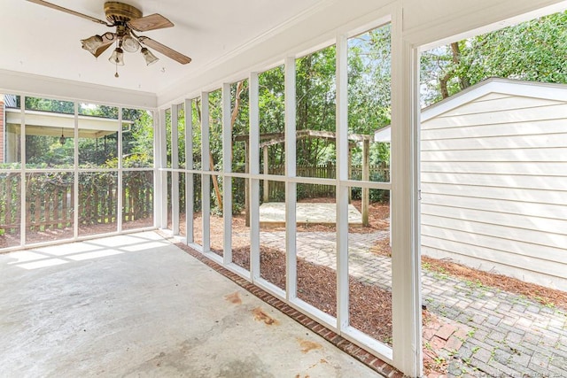 unfurnished sunroom featuring ceiling fan