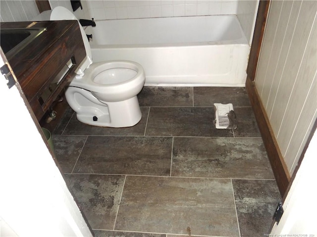 bathroom featuring a tub to relax in and toilet