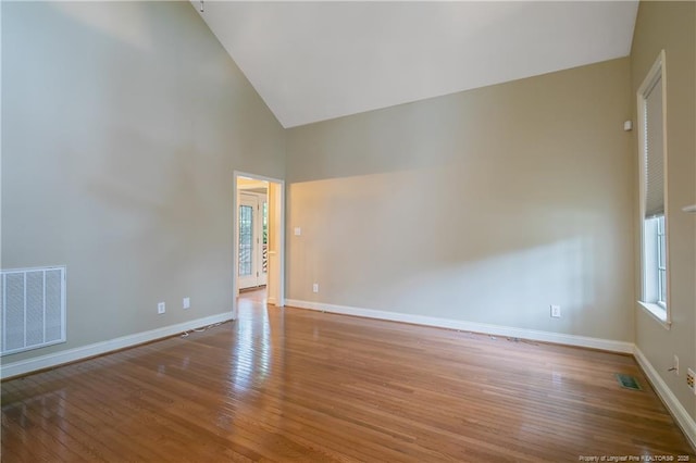 unfurnished room featuring high vaulted ceiling and light hardwood / wood-style floors