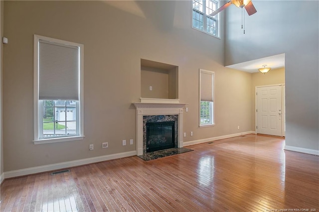 unfurnished living room featuring plenty of natural light, a fireplace, and light wood-type flooring