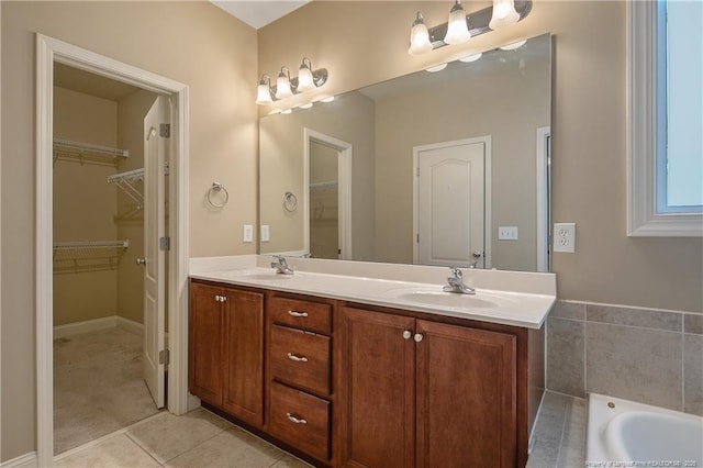 bathroom featuring a tub to relax in, vanity, and tile patterned flooring