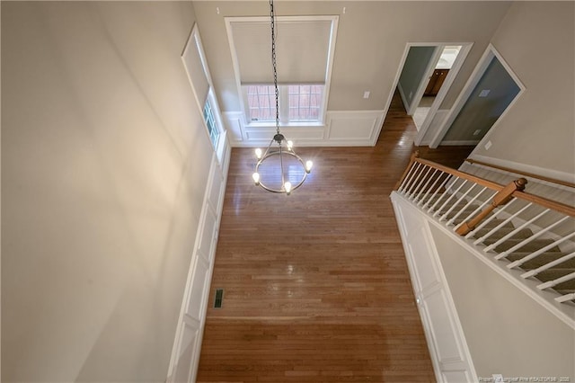 hall featuring dark wood-type flooring and a chandelier