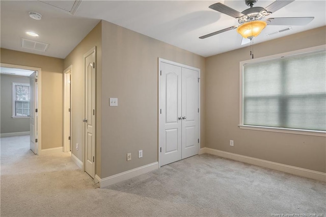 unfurnished bedroom featuring light carpet, a closet, and ceiling fan