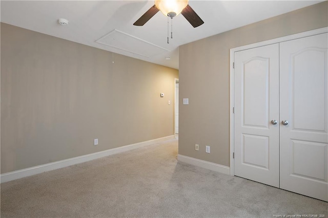 unfurnished bedroom featuring light colored carpet, a closet, and ceiling fan