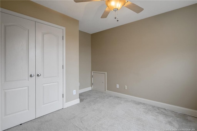 unfurnished bedroom with light carpet, a closet, and ceiling fan